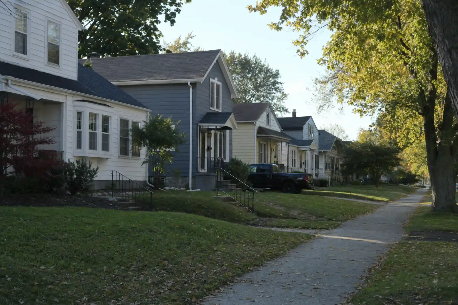 A tree-lined residential street of single-family homes